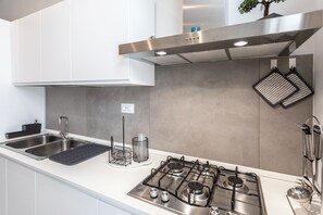 Een oven, kookgerei, borden en bestek, een eettafel