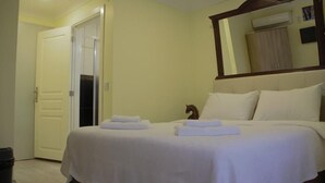 A hotel room with a bed, a mirror, and a door. - Ada İnan Pansiyon (Adalar)
