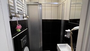 A compact bathroom with a toilet, sink, and shower. - Ada İnan Pansiyon (Adalar)