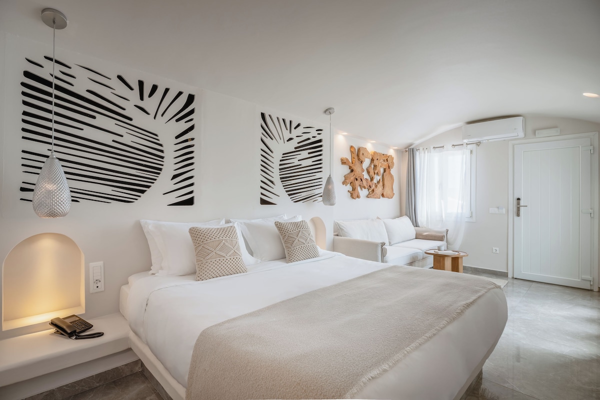 Un dormitorio moderno con una cama grande, una mesita de noche con lámpara y una obra de arte en la pared.