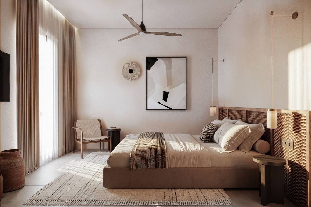 Une chambre moderne avec un grand lit, un ventilateur de plafond, une table de chevet, une chaise et une œuvre d’art accrochée au mur.