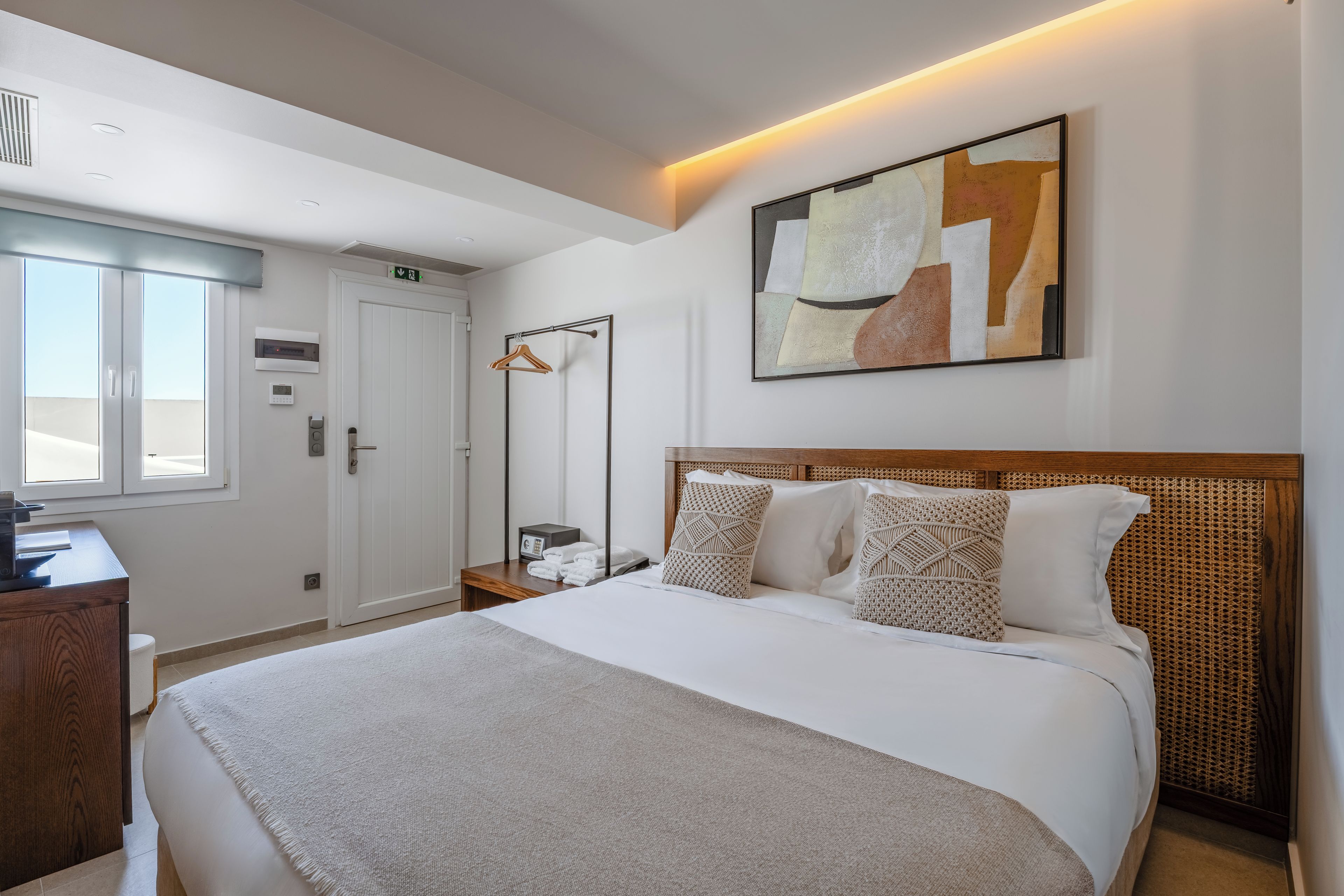 A hotel room with a bed, a desk, a wardrobe, and a bathroom.
