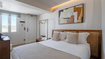 A hotel room with a bed, a desk, a wardrobe, and a bathroom.