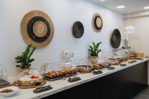 Un comptoir de buffet proposant une variété de plats, des couvercles en verre transparent et des décorations murales.