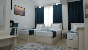 A hotel room with two beds, a desk, a chair, a coffee machine, and a painting on the wall. - HOTEL MERCURI MERIDIAN (Bukhara)