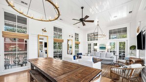 A spacious living room with a wooden dining table, white sofas, and a ceiling fan. - Escape To WaterColor with Exclusive Beach Club Access and Free Bikes Included in Every Stay (Santa Rosa Beach)