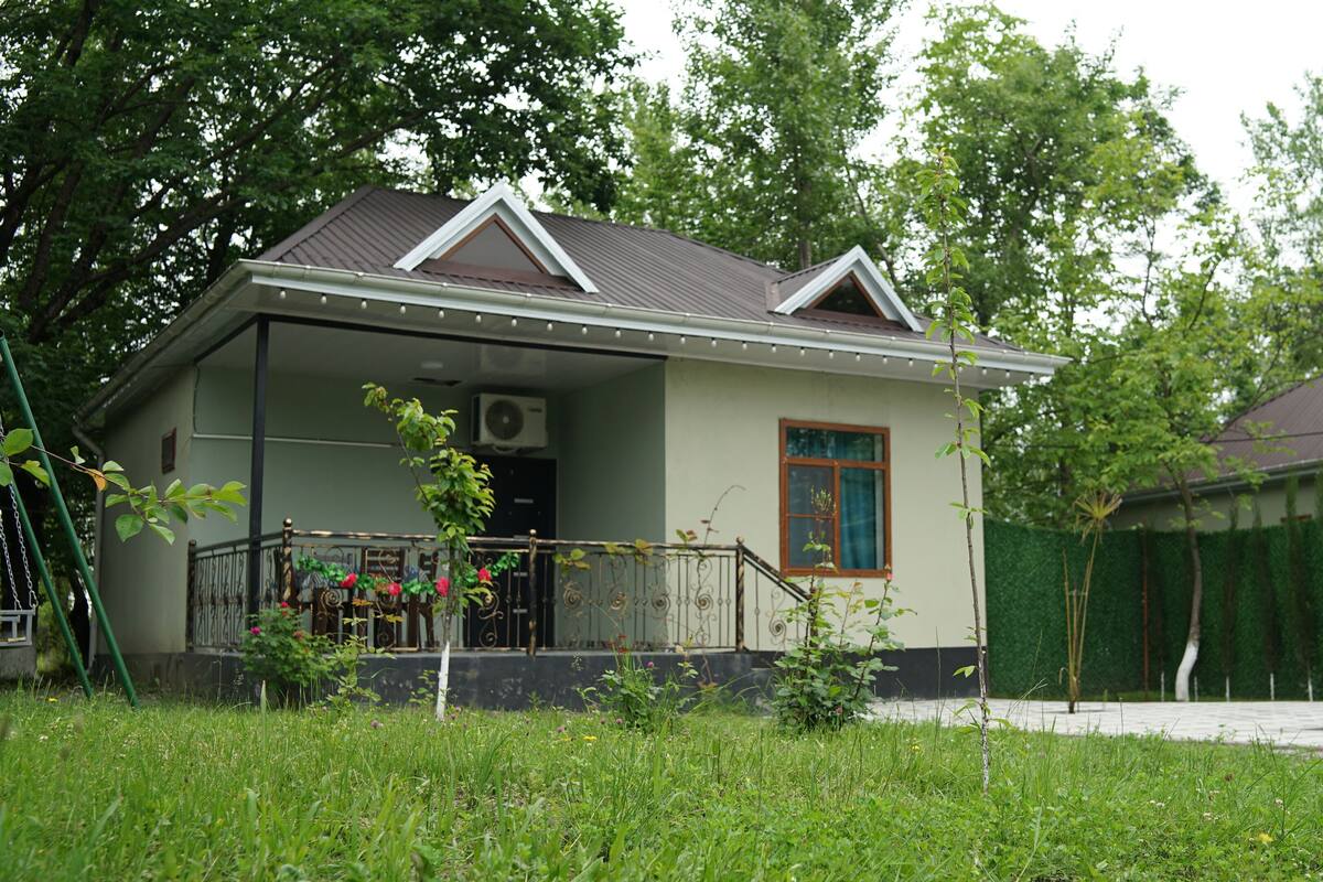Eenlaags huis met een schuin dak, een voortuin en een kleine veranda.