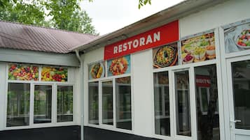 A restaurant with a red sign and large windows displaying food images.