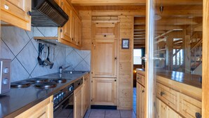 A kitchen with wooden cabinets, a stainless steel stove, and a tiled backsplash.