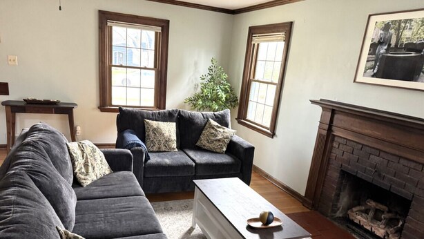 A living room with a dark gray sectional sofa, a white coffee table, and a fireplace.