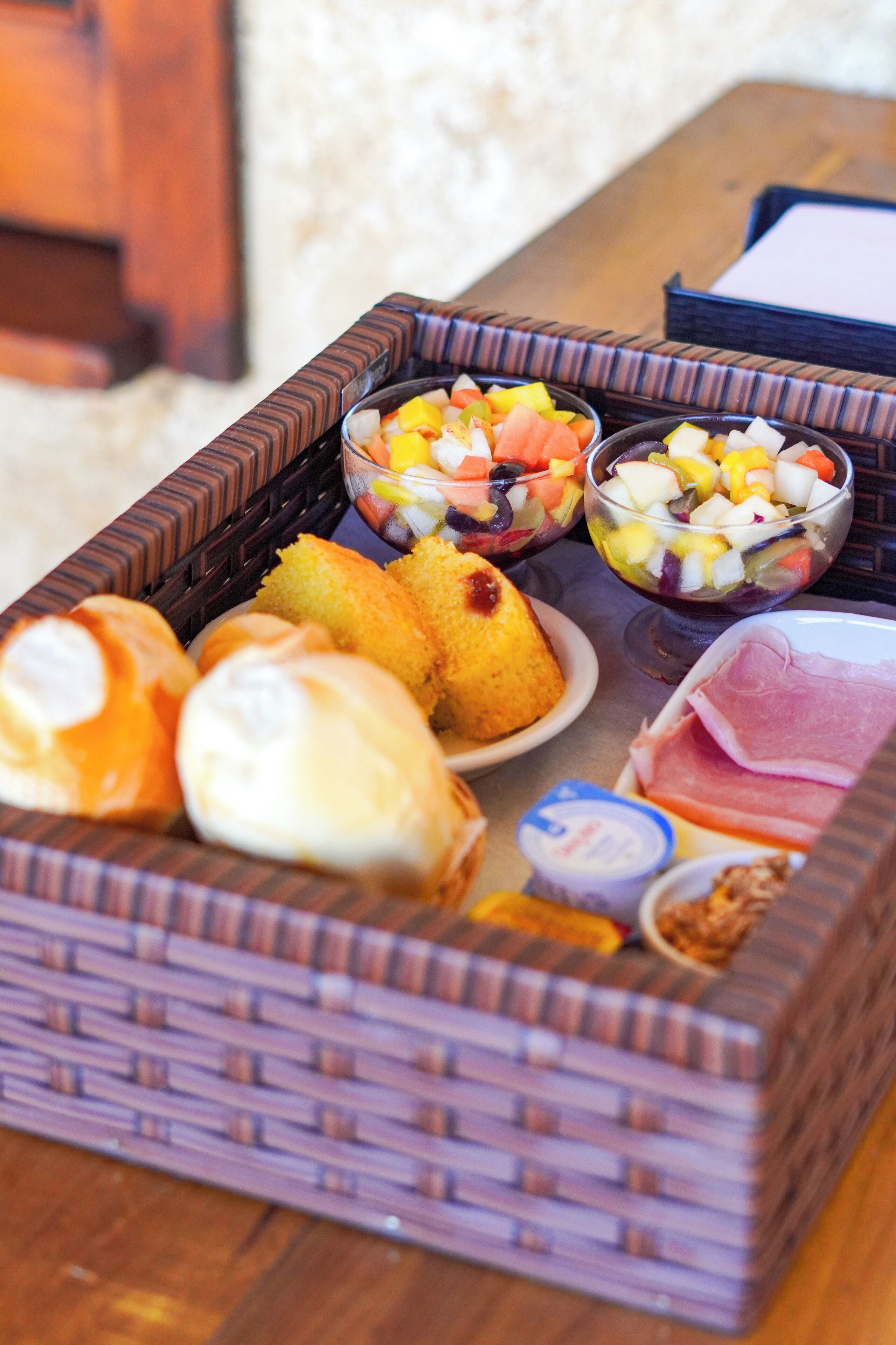 A tray with various food items including bread, fruit salad, and cheese.