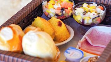 A tray with various food items including bread, fruit salad, and cheese.