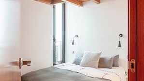 Une chambre à coucher avec un lit, une fenêtre et une porte.