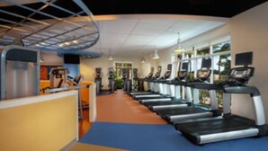 Un gimnasio con cintas de correr, equipamiento de ejercicio y una zona de recepción.