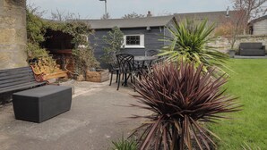 A patio area with a table and chairs, a bench, and a potted plant. - 6 New Street (Elgin)