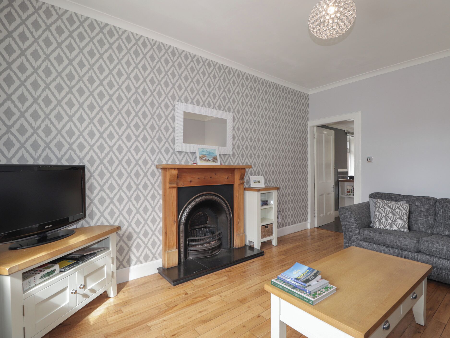 A living room with a fireplace, a television, a sofa, and a coffee table.