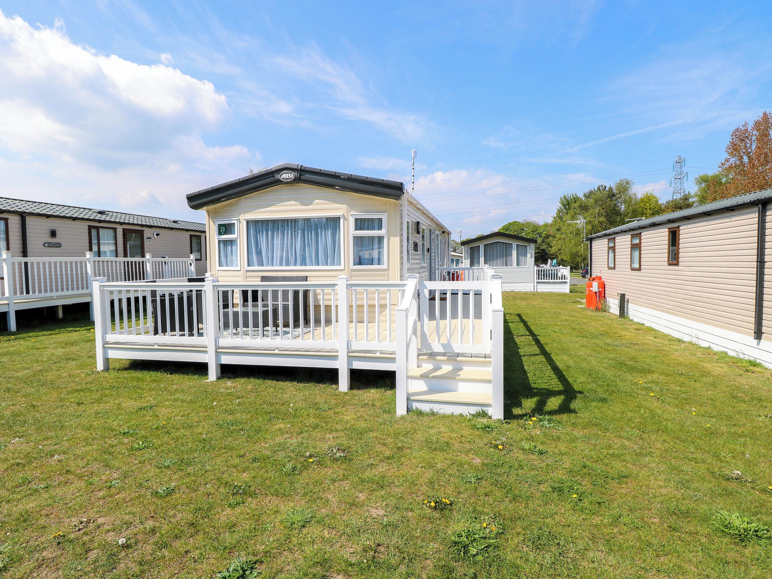 A mobile home with a white deck and a small porch.