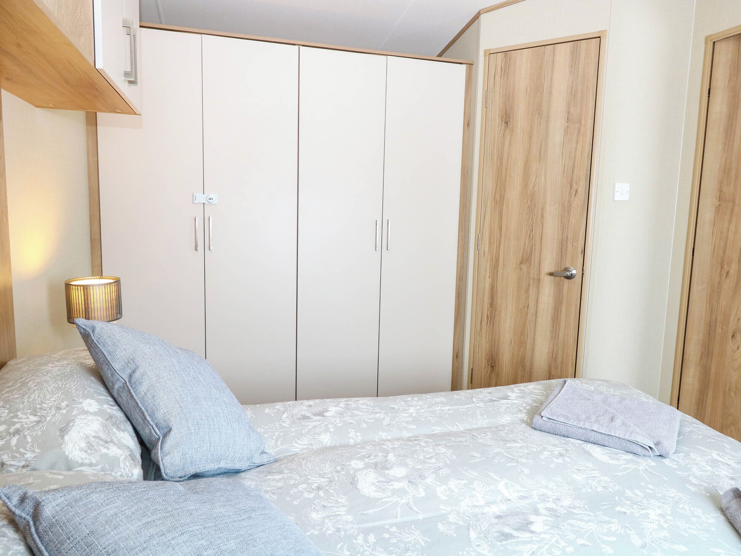 Un dormitorio con cama, armario y puerta.