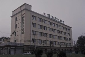A multi-story building with a flat roof and a sign indicating it is a hotel. - Guantong Modern Hotel (Beijing Qianmen) (Beijing)