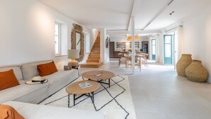 Un vaste espace de vie comprenant un canapé, une table basse et un escalier menant à la salle à manger.