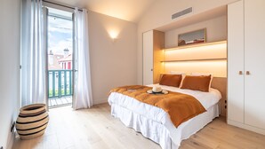 Une chambre à coucher avec un lit, une grande fenêtre et une vue sur un balcon.