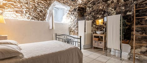 Cozy retreat with a rustic ceiling, comfortable bed, and a small window.