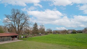 A rural landscape with a large open field, a building with a red roof, and a clear blue sky with clouds. - Le Cheval Blanc - Proche Amiens, grand jardin (Damery)