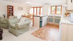 Un espacio habitable compacto con comedor, kitchenette y sofá.