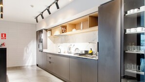 A modern kitchen with a marble countertop, built-in appliances, and a glass-fronted display case. - Luxury 1-bedroom apartment near WTC Montevideo with infinit pool (Montevideo)