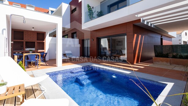 A modern house with a swimming pool, outdoor seating, and a kitchen area. - Villa Terracota by Acasadascasas (Mafra)