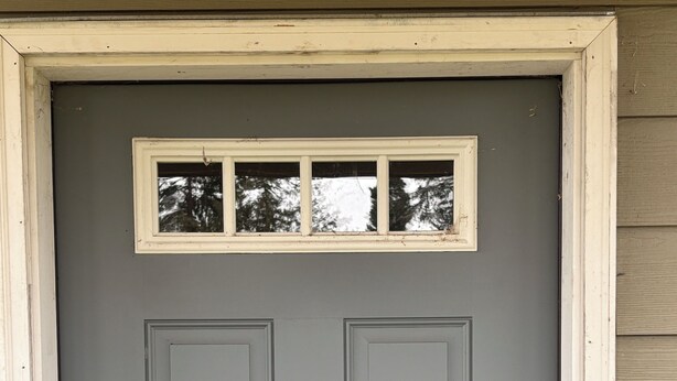 A grey door with a window above it, a doorbell, and a mail slot. - Charming 2-bedroom attached apartment with AC, WiFi in adorable Creswell (Creswell)