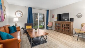 A living room with a sofa, coffee table, television, and a cabinet. - 3BR Walk-In Condo | Spacious Deck | Sleeps 11 (Branson)