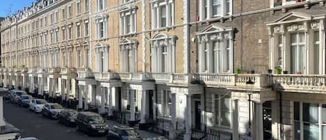 A row of terraced houses with a street in front.