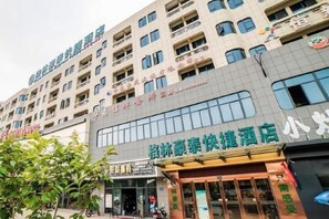A multi-story building with a ground-level restaurant and a hotel sign above it. - GreenTree Inn (Ningbo Beilun Yintai City Huashan Road) (Ningbo)