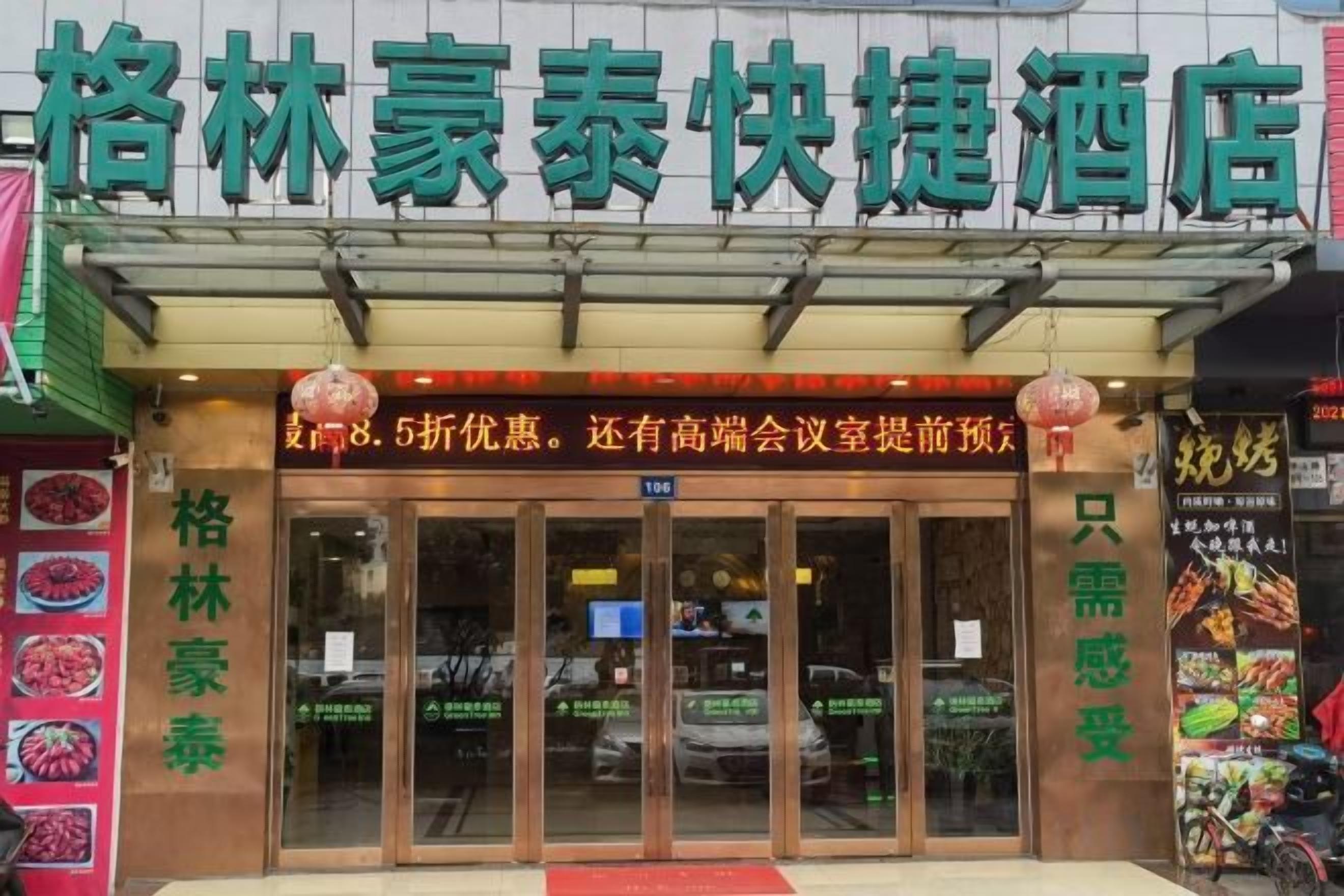 A hotel entrance with a signboard and a red lantern.