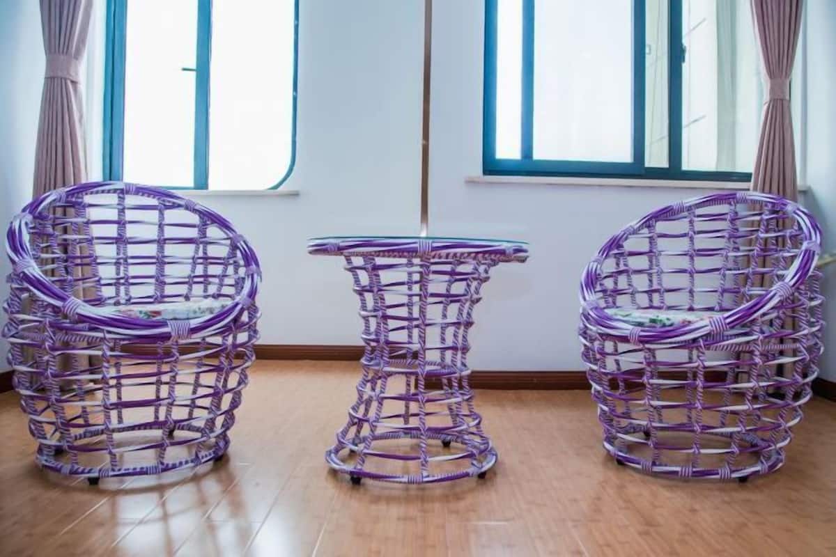 A room with two wicker chairs and a small round table.