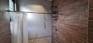 A bathroom with a wooden wall, a marble-tiled shower area, and a shower curtain. - Depto Pino Blanco (Monterrey)