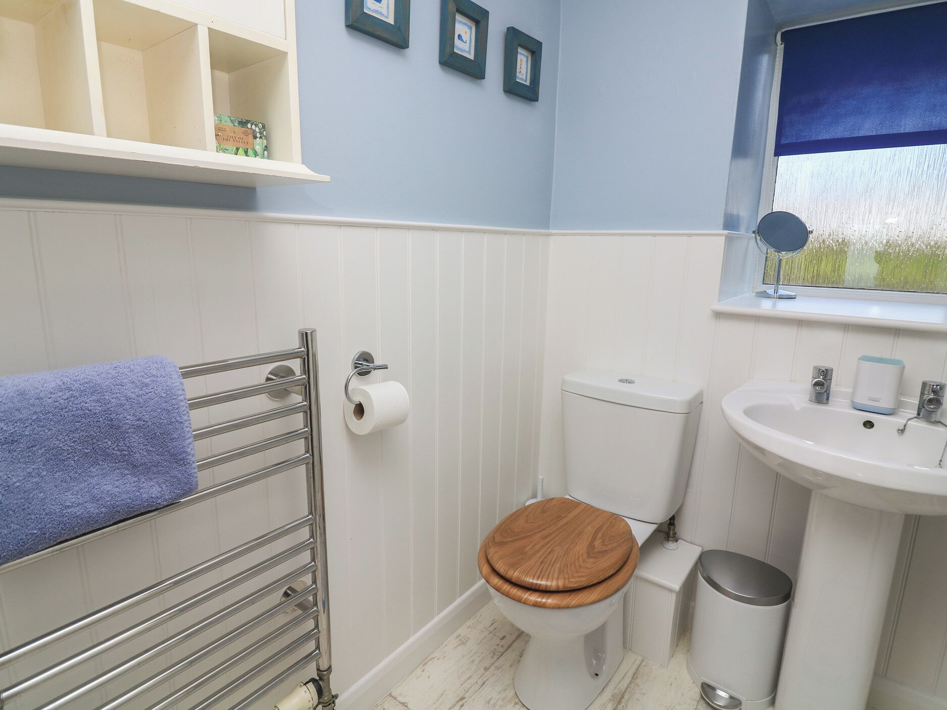 A bathroom with a toilet, sink, and towel rack.