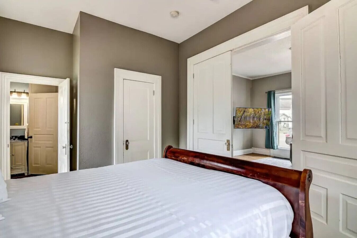 Une chambre à coucher avec un lit, une armoire et un miroir.