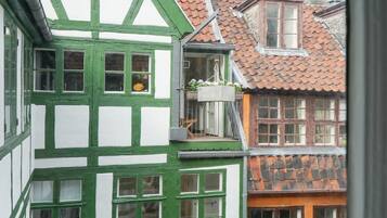 Een traditioneel vakwerkhuis met een balkon en een schotelantenne.
