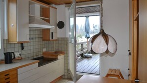 A compact kitchen with white cabinets, a wooden countertop, and a hanging light fixture. - PentArtHouse Apartment (Burscheid)