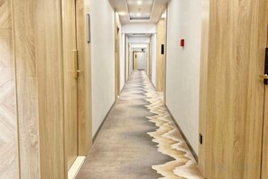 A long, narrow hallway with wooden doors on both sides and a carpeted floor. - Yuzhan (Shanghai)