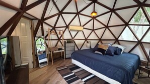A bedroom with a geometric ceiling, a bed with blue bedding, a wooden floor, and a view of the outdoors. - Peaceful House, Private Pool, 2 cars included (Akumal)