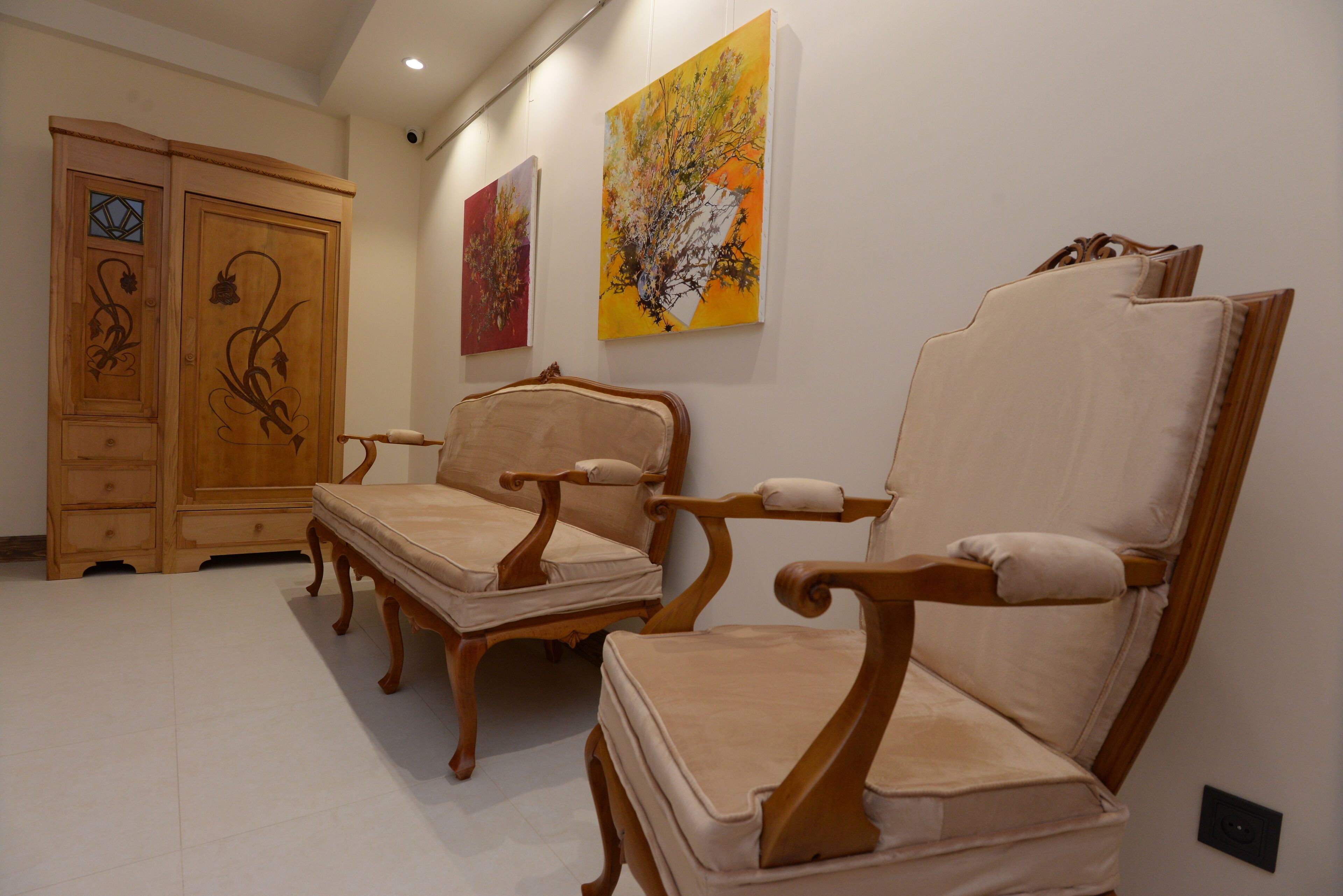 Une pièce qui contient deux chaises en bois et un meuble.