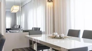 Un comedor moderno con una mesa larga, asientos acolchados y elementos decorativos.