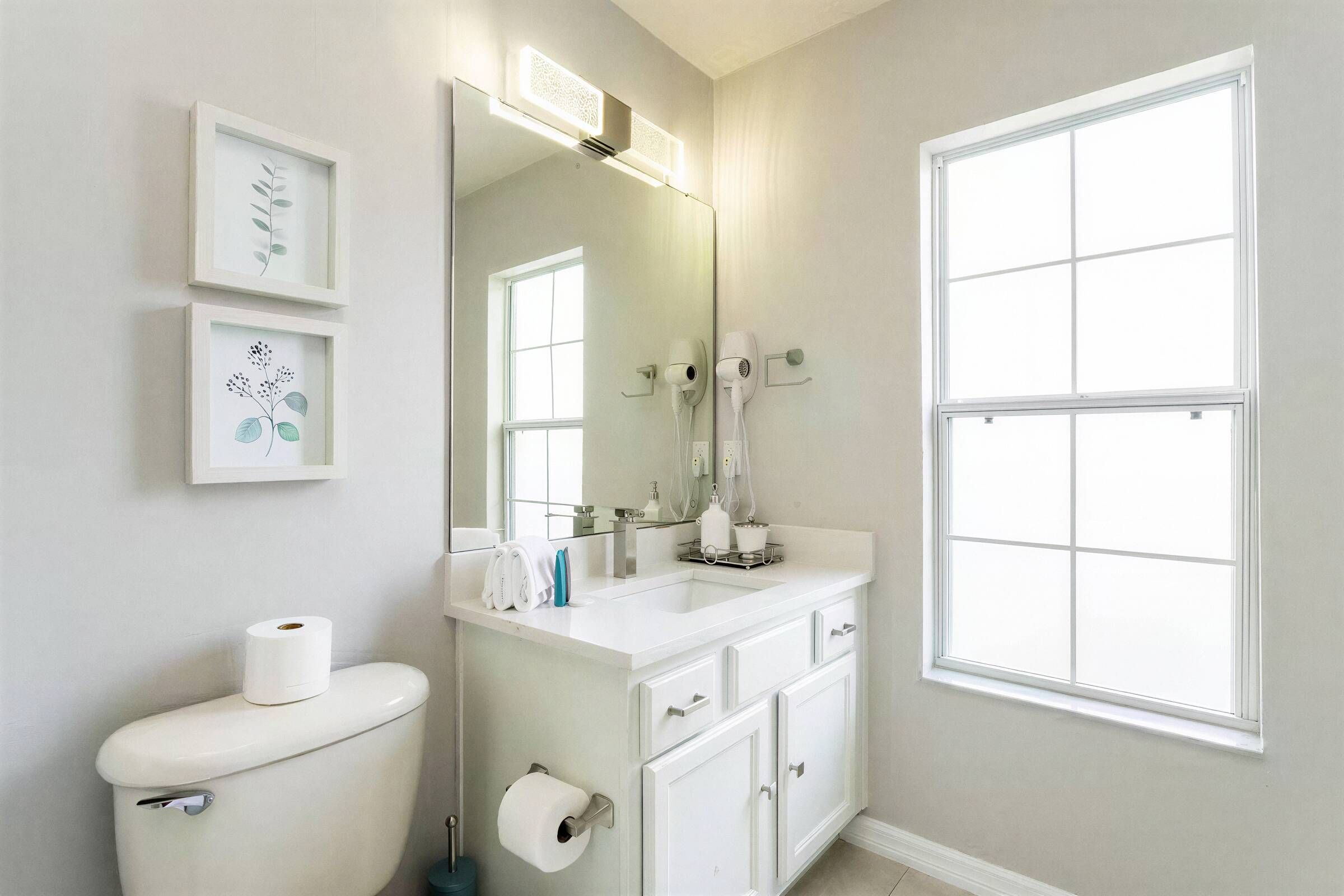 Un bagno moderno con il water, un lavandino e un'ampia finestra.