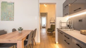 Una cocina moderna con una mesa de comedor de madera, sillas y un fregadero.