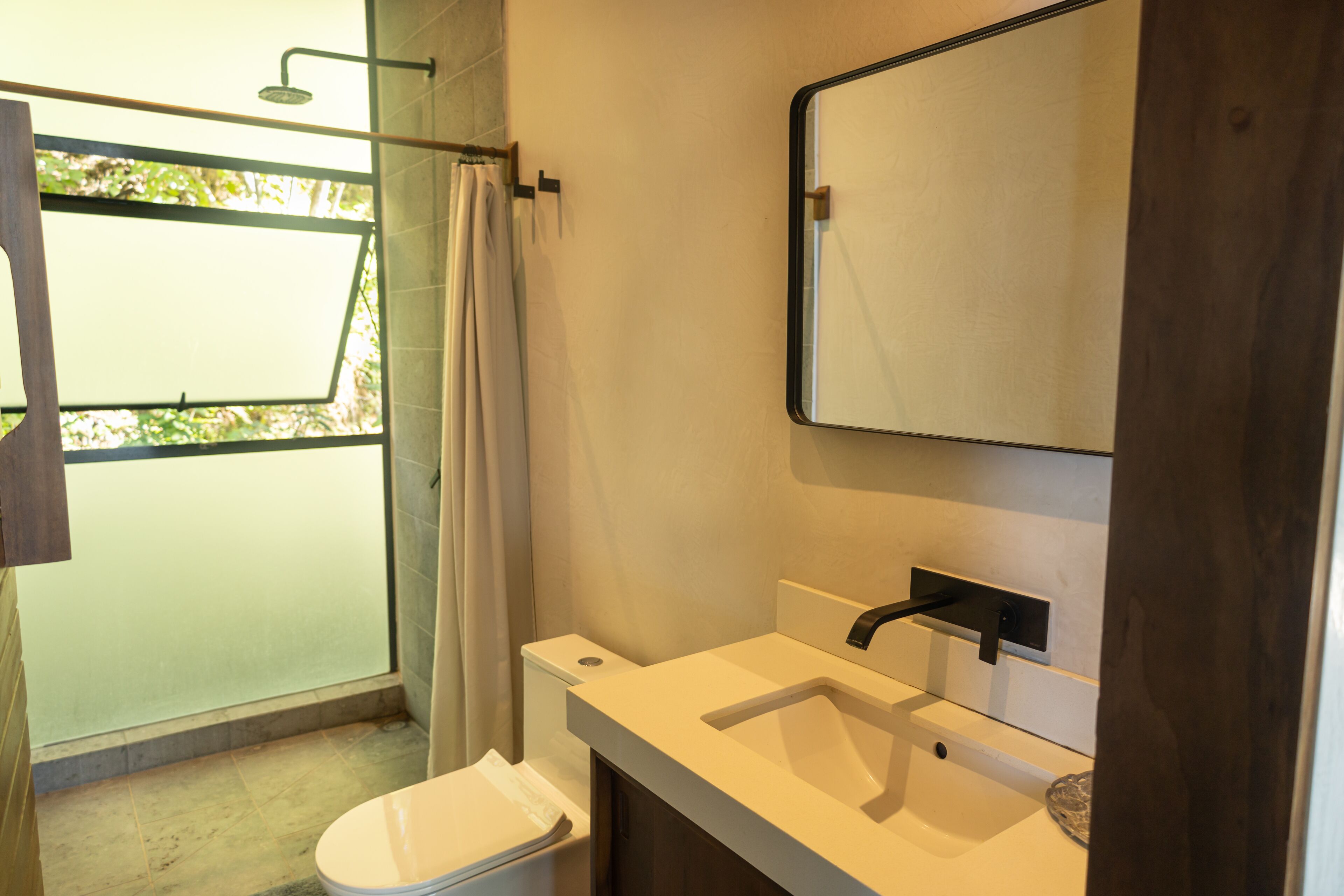 Une salle de bain comprenant des toilettes, un lavabo et une douche.