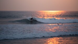 A sunset over the ocean with waves and surfers. - Incredible house with sea view in Santa Teresa (Saint Teresa)
