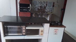 A kitchen with a built-in oven, a microwave, and a stove. - Pousada Sossego Ronaldo e Clarinha  (Santarem)